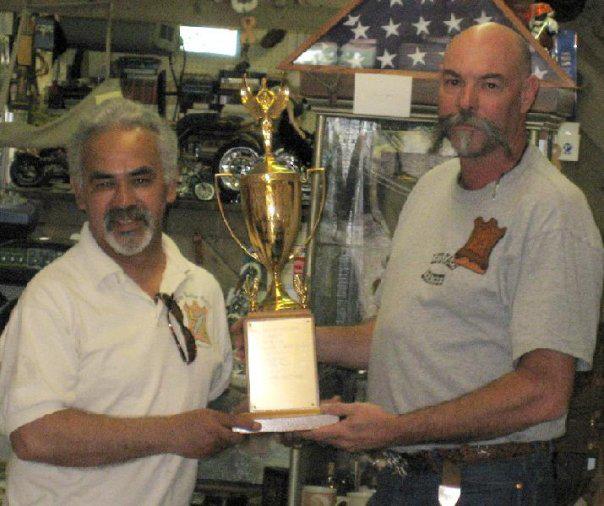 Robert presenting the weaver memorial perpetual trophy to WC for outstanding service to The Leathercraft Guild